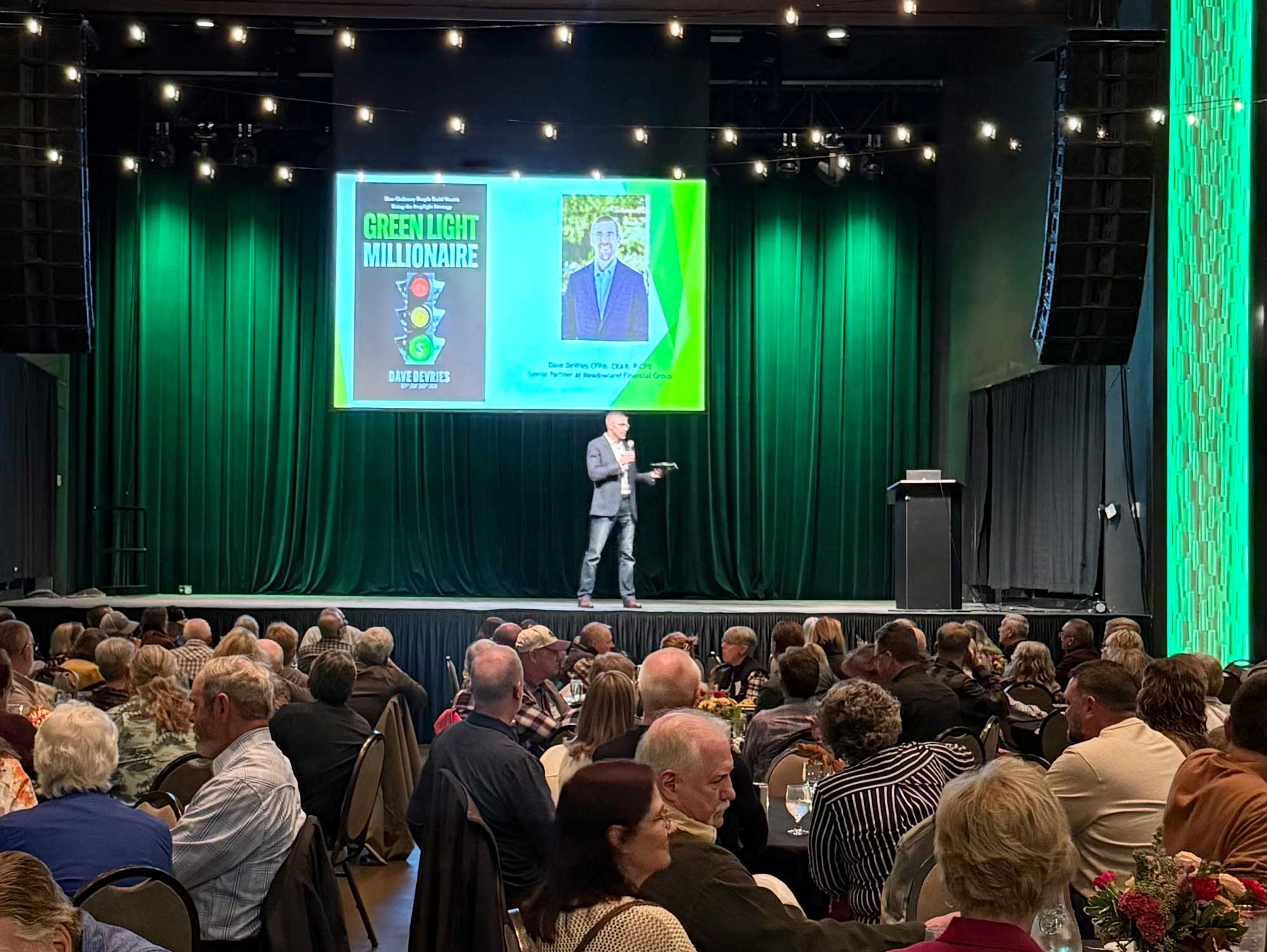Dave DeVries speaking about Green Light Millionaire to a large crowd of people
